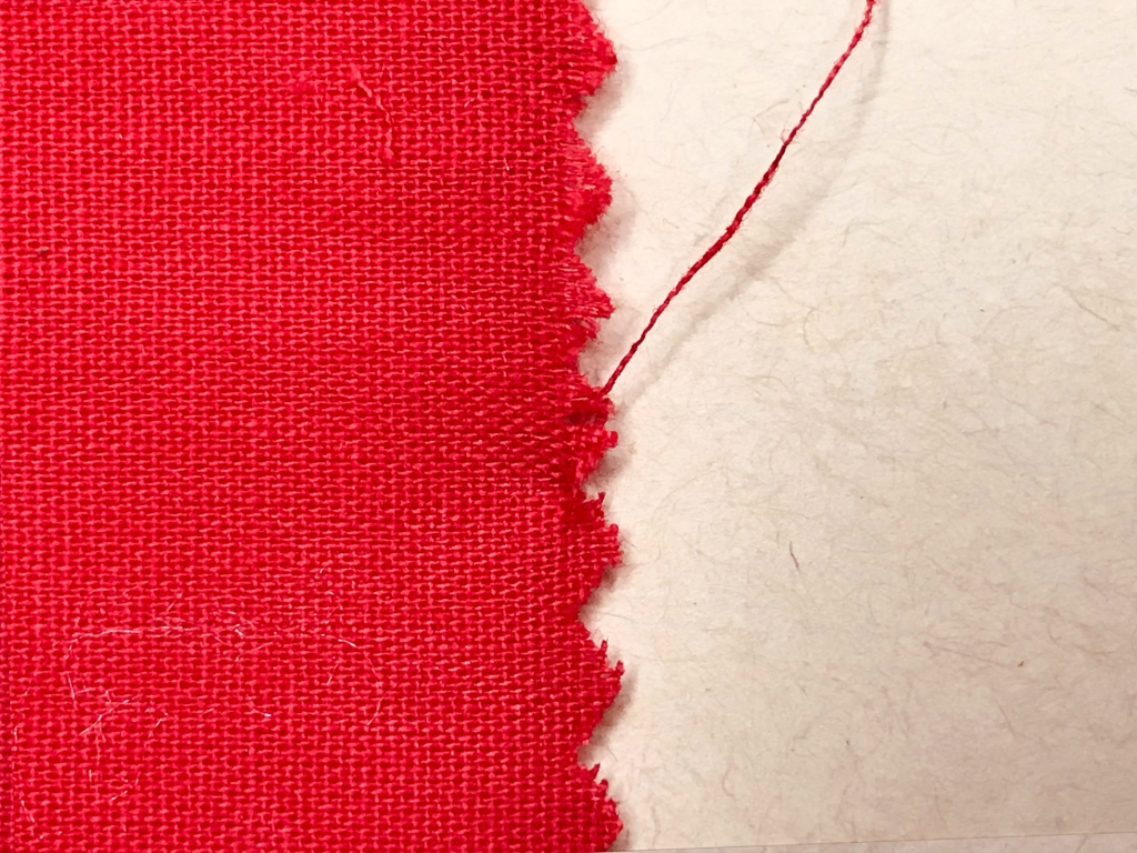 Woven cotton fabric cut with pinking shears on the grain line.